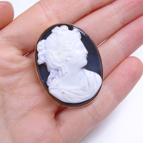 676 - A 19th century relief carved shell cameo panel brooch on chalcedony backing, depicting Classical fem... 