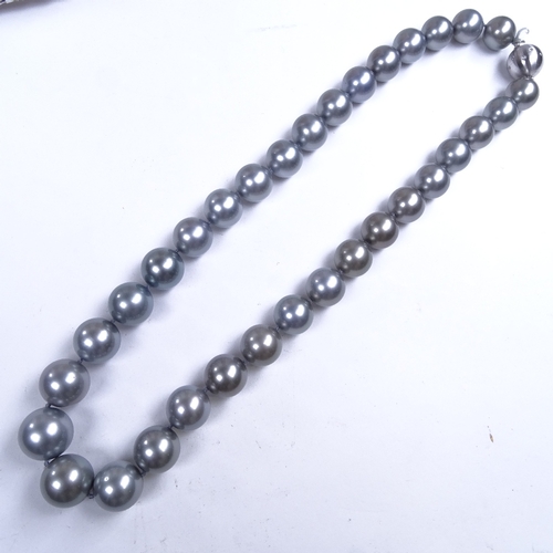 687 - A single-row Princess length black pearl necklace, with 18ct white gold diamond set sphere clasp, pe... 