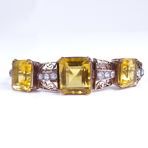 748 - A mid-20th century unmarked gold yellow stone and white sapphire panel bracelet, with pierced scroll... 