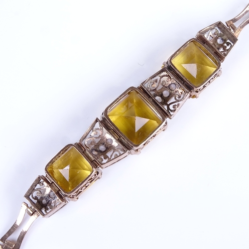 748 - A mid-20th century unmarked gold yellow stone and white sapphire panel bracelet, with pierced scroll... 