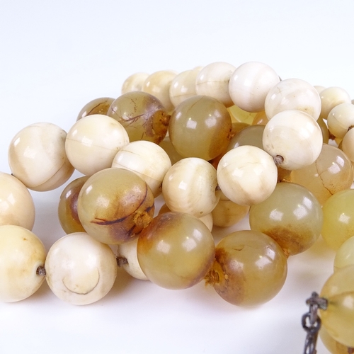 749 - A Chinese nephrite? polished bead necklace, length 56cm, and a 19th century ivory bead necklace, len... 