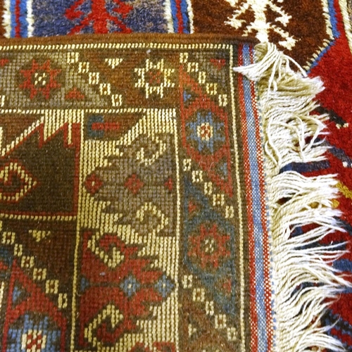 303 - A Caucasian red and blue ground handmade wool rug