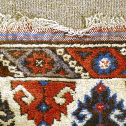 303 - A Caucasian red and blue ground handmade wool rug