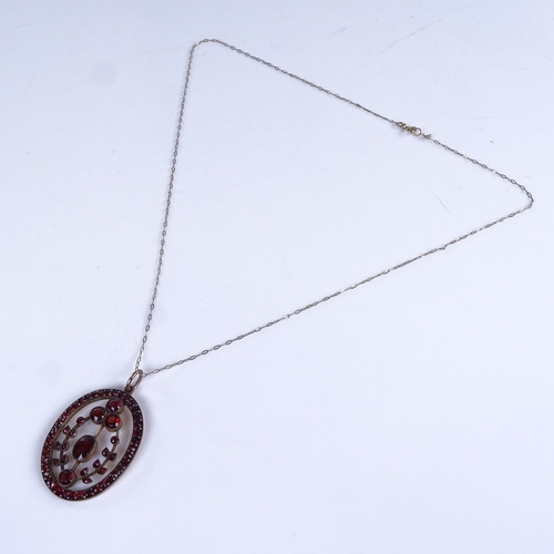 769 - An early 20th century unmarked yellow metal garnet pendant necklace, on 9ct trace link chain, pendan... 