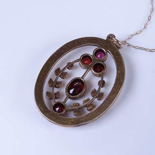 769 - An early 20th century unmarked yellow metal garnet pendant necklace, on 9ct trace link chain, pendan... 