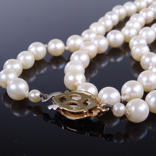 788 - A late 20th century single-strand opera length cultured pearl necklace, on 9ct gold garnet clasp, ne... 