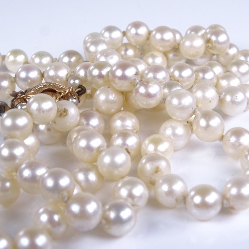 788 - A late 20th century single-strand opera length cultured pearl necklace, on 9ct gold garnet clasp, ne... 