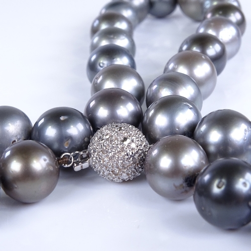 792 - A modern single-strand Princess length black pearl necklace, with 14ct white gold diamond set clasp,... 