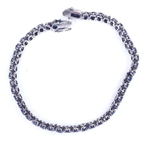 813 - A modern sterling silver sapphire tennis line bracelet, bracelet length 19cm, 10.4g