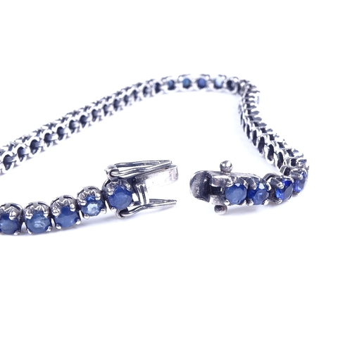 813 - A modern sterling silver sapphire tennis line bracelet, bracelet length 19cm, 10.4g