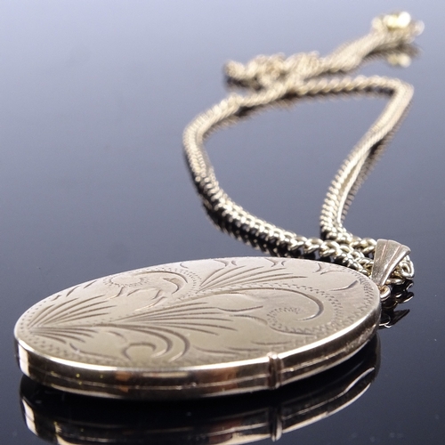 815 - A late 20th century 9ct gold oval locket pendant necklace, on 9ct curb link chain with gold plated s... 