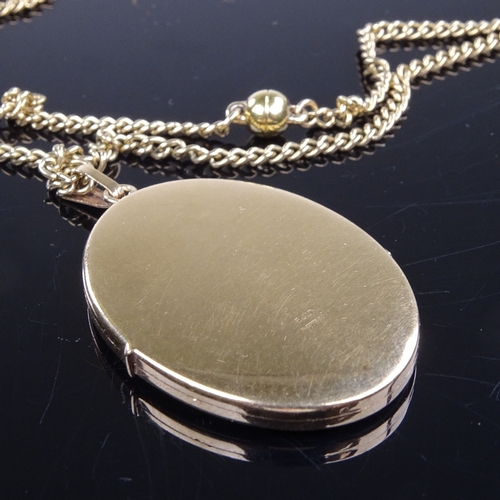 815 - A late 20th century 9ct gold oval locket pendant necklace, on 9ct curb link chain with gold plated s... 