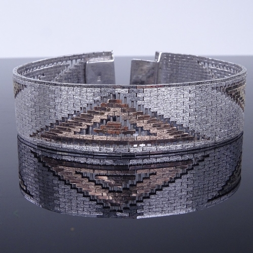 943 - A sterling silver and silver-gilt geometric design gate link articulated bracelet, bracelet length 1... 