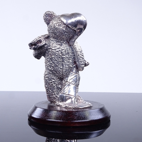 968 - A modern novelty silver-clad teddy bear figurine on wood stand, overall height 9.5cm