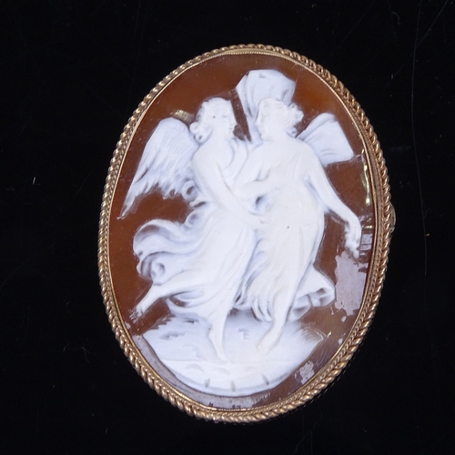 973 - A late 20th century relief carved cameo shell panel brooch, depicting 2 winged angels, in 9ct gold r... 