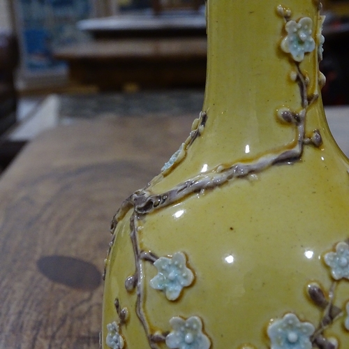 323 - A Chinese yellow glaze narrow-neck vase, with relief  prunus design, height 18cm