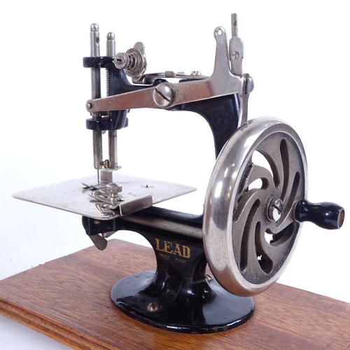 16 - A Vintage Japanese portable Lead sewing machine, in bentwood travelling case, machine length 20cm