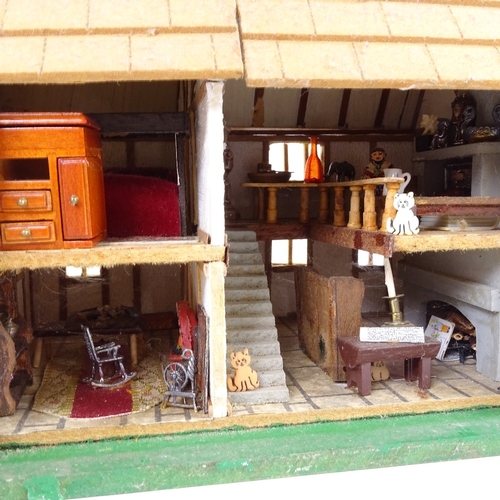 24 - A handmade model Tudor design doll's house, complete with contents and hinged openings, height 21cm