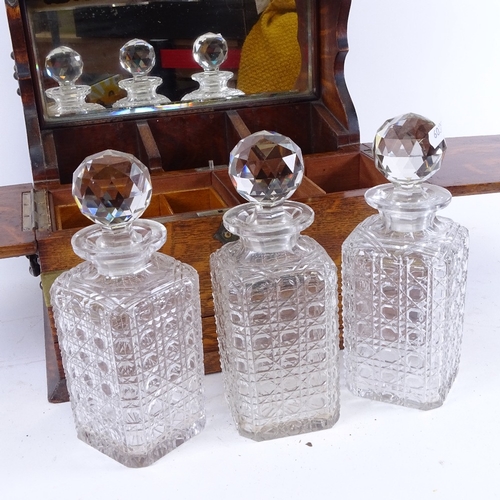 84 - A Victorian oak tantalus with electroplate mounts, containing 3 square cut-glass decanters, all unma... 