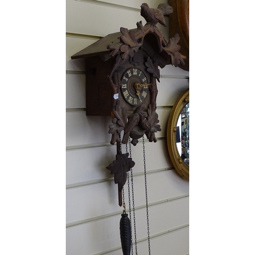 124 - A Vintage German Black Forest cuckoo clock, bird and leaf decorated case with pine cone weights and ... 