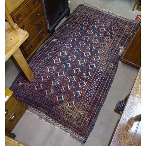 1411 - A red ground Afghan design rug with symmetrical pattern, 190cm x 110cm