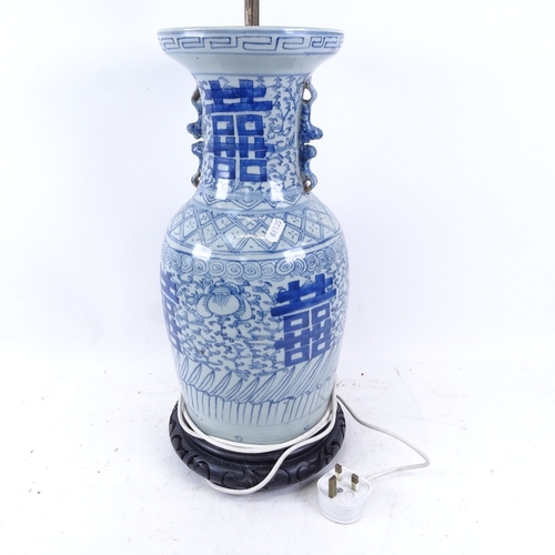 518 - An Oriental blue and white porcelain lamp on carved wood base, height overall 70cm