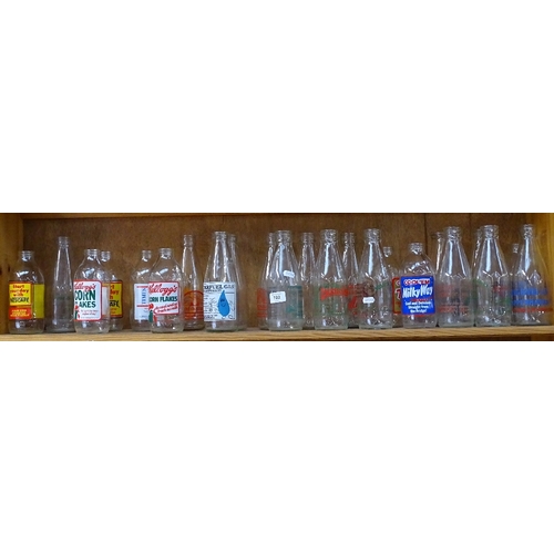 702 - A shelf of 1980s advertising milk bottles, and dairy bottle