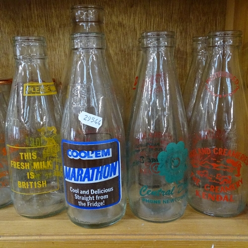 722 - A shelf of 1980s advertising milk bottles, and various dairy bottles