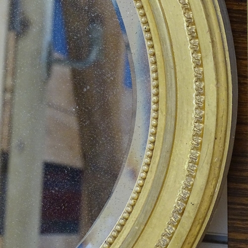 778 - A large gilt-gesso framed oval bevel-edge wall mirror, 60cm x 86cm