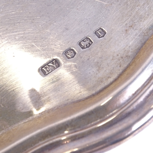 1113 - A silver salver with scalloped edge, on cast scrolled feet, Sheffield 1934, 16oz