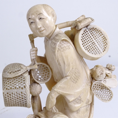 162 - A Japanese ivory okimono of a basket seller, Meiji Period, with inset signed jade plaque under base,... 