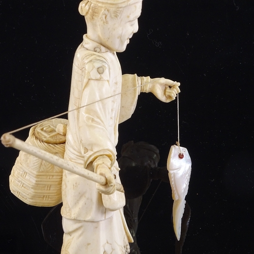 164 - A Japanese ivory okimono depicting a fisherman with a mother-of-pearl fish, Meiji Period, height 25c... 