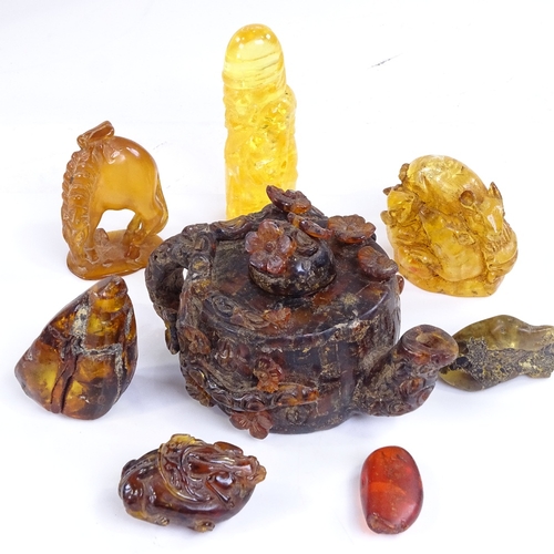 217 - A group of amber, including a relief carved Chinese teapot, length 10cm