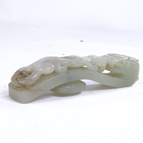 323 - A Chinese relief carved jade dragon design buckle, length 11.5cm