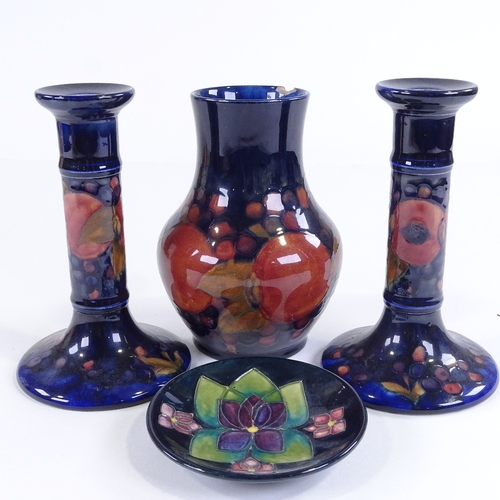 419 - MOORCROFT POTTERY - pair of pomegranate design candlesticks, height 18cm, a vase, height 17cm, and a... 