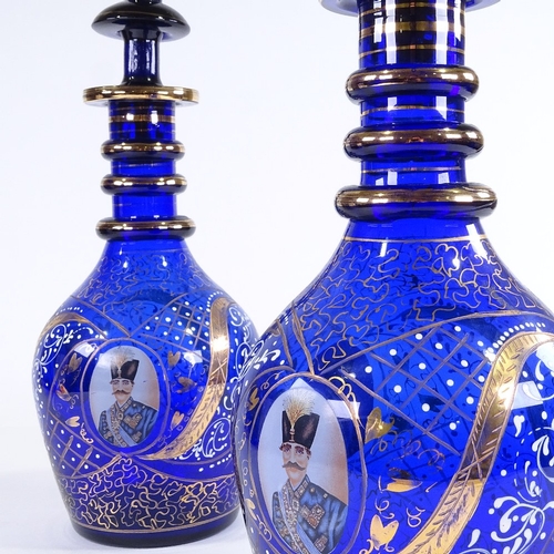 457 - A pair of gilded blue glass Ottoman style large decanters, with portrait panels, largest height 57cm