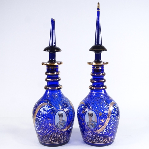 457 - A pair of gilded blue glass Ottoman style large decanters, with portrait panels, largest height 57cm