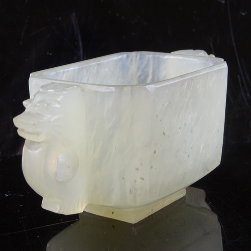 474 - A Chinese pale celadon jade 2-handled Gui cup, dragon decorated handles, 8cm across, 38mm