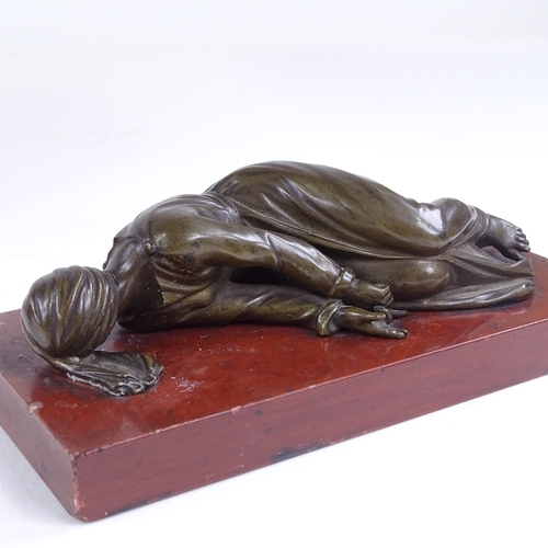 478 - A 19th century patinated bronze sculpture, prostrate figure, unsigned, on rouge marble base, base le... 