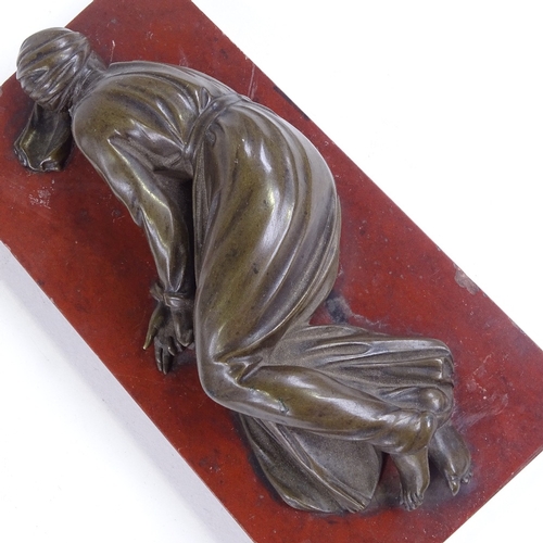 478 - A 19th century patinated bronze sculpture, prostrate figure, unsigned, on rouge marble base, base le... 