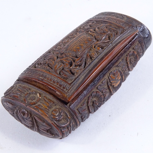 493 - A 19th century coquilla nut snuffbox, all over relief carved musical instruments in floral border, l... 