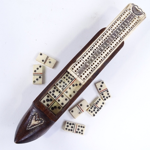 496 - A 19th century carved wood shoe design games box, with bone cribbage board sliding lid enclosing a s... 