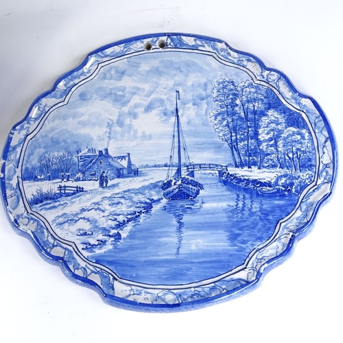 510 - A pair of Delft blue and white pottery wall plaques, with painted river scenes, width 38cm, height 3... 