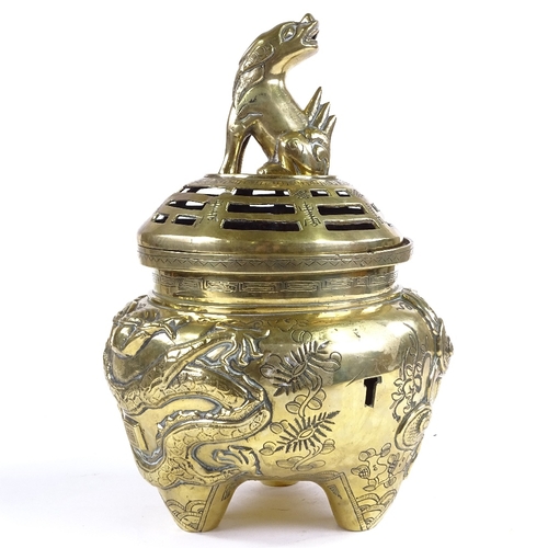 520 - A Chinese polished bronze incense burner and cover, with dragon knop and relief moulded dragon surro... 