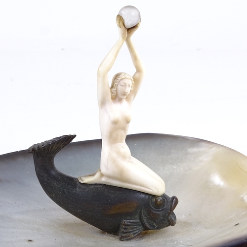 524 - An Art Deco abalone shell dish, surmounted by a carved ivory nude woman on a bronze gurgle fish, dis... 