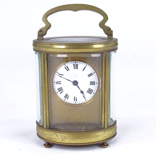 1069 - A 19th century oval brass-cased carriage clock timepiece, white enamel dial with Roman numeral hour ... 