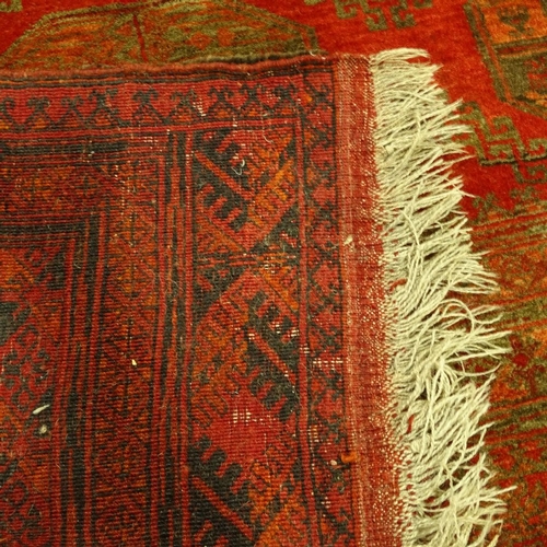 288 - A Persian handmade red ground geometric design rug, 290cm x 208cm.