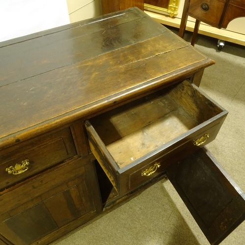 387 - An 18th century panelled oak dresser base, with 3 frieze drawers and panelled cupboards under, lengt... 