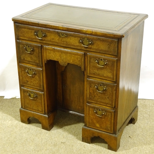 390 - A small Queen Anne style walnut kneehole desk, with inset green leather top, alcove drawer and cupbo... 