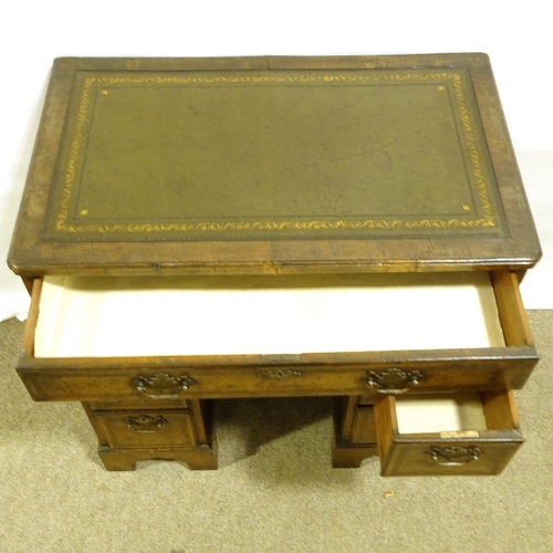 390 - A small Queen Anne style walnut kneehole desk, with inset green leather top, alcove drawer and cupbo... 